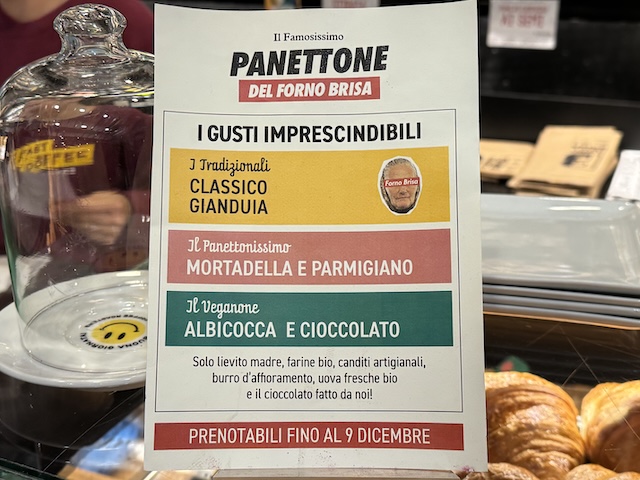 Cartel informativo de panettone artesanal con diferentes sabores en una panadería de Bolonia