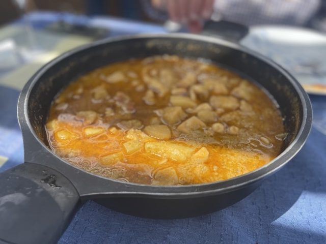 Sartén de hierro fundido con sepia con patatas