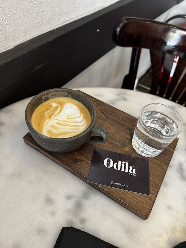 Latte en Odila Café en Tarragona con un vaso de agua
