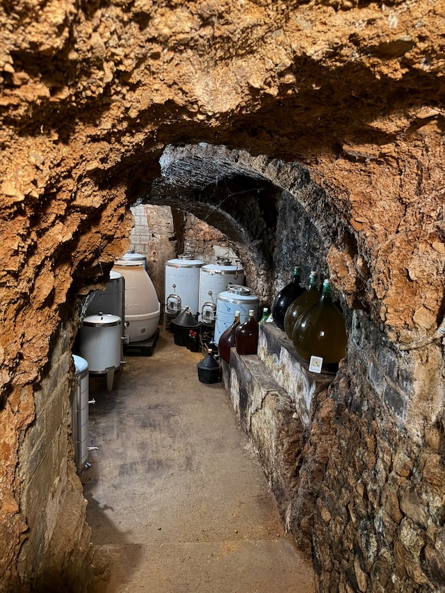 Interior de la bodega subterránea en La Vilueña, con depósitos y damajuanas